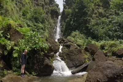 Dense rainforest canopy framing the falls with mist in the air, morne trois pitons waterfall amphitheatre surrounding Trafalgar, Dominica.