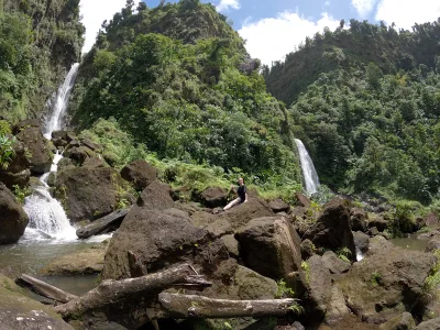 Crowded viewing deck with safety rails facing both cascades, trafalgar falls dominica visitor infrastructure at the end of the short walk, Dominica.