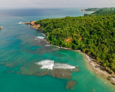 Snorkeller-ready shallows and clear water over pale sand at Batibou Beach, calibishie dominica day-trip swimming spot, Dominica.