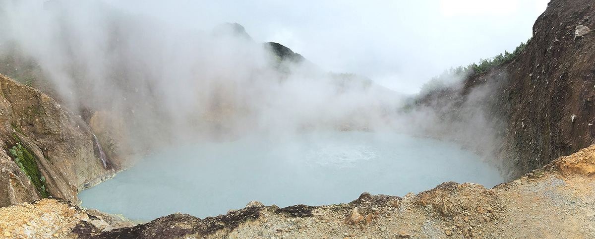 Steam veiling the grey-blue Boiling Lake inside a volcanic crater rim, boiling lake dominica’s legendary geothermal pool on the cross-island hike, Dominica.