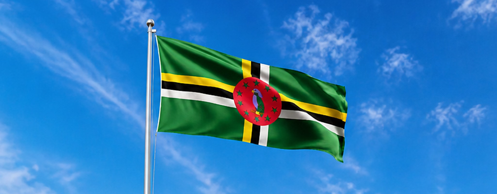 Dominica’s flag before forested Morne Bruce above Roseau, emblem for history of dominica from Kalinago roots through colonial rule to independence, Dominica.