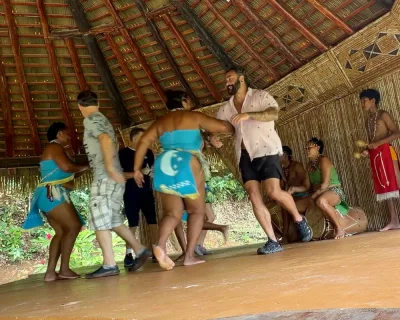 Visitors joining a circle dance on the performance area, kalinago cultural village dominica live music and movement demonstration, Dominica.