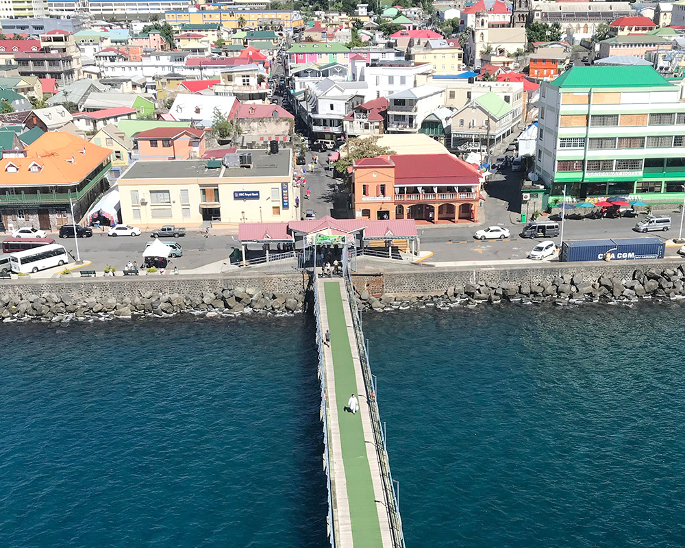 Colourful Bay Front façades, cruise pier, and green hills behind Roseau’s waterfront, roseau dominica’s compact capital clustered along the Caribbean shore.
