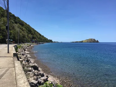 Calmer Caribbean-side bay backed by green hills at Scotts Head, soufriere scotts head marine reserve access point for snorkellers and divers, Dominica.