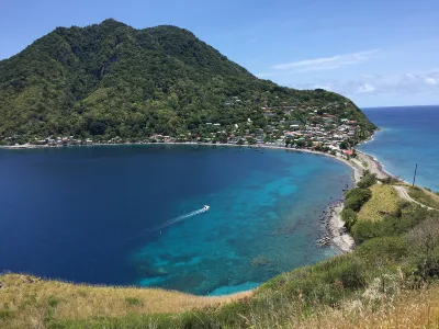 Aerial perspective of Dominica’s southern tip with village and reefs visible, scotts head dominica landmark at the island’s end, Dominica.
