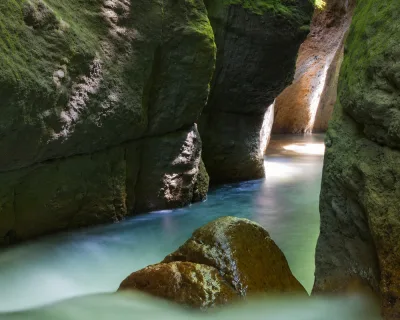 Low light in the inner waterfall chamber with wet rock walls glistening, titou gorge dominica climax chamber at the canyon’s end, Dominica.